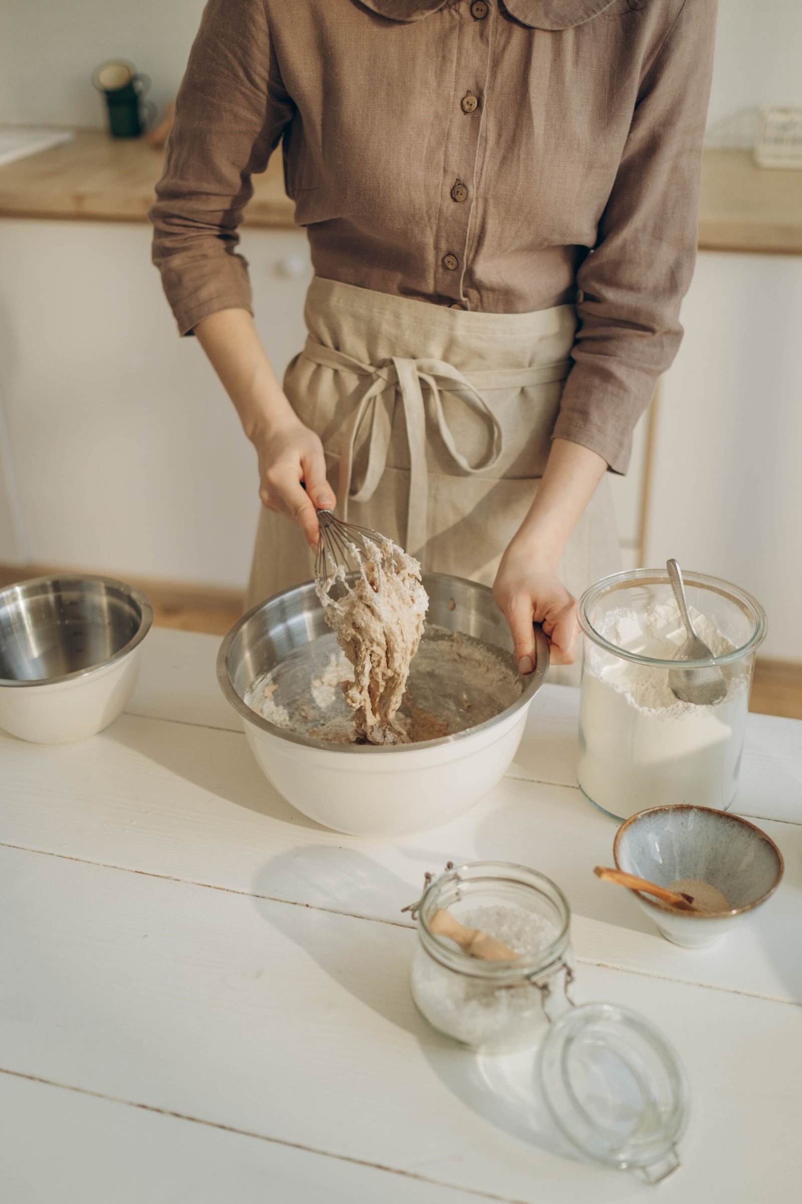 Baker whisking dough at a home kitchen counter